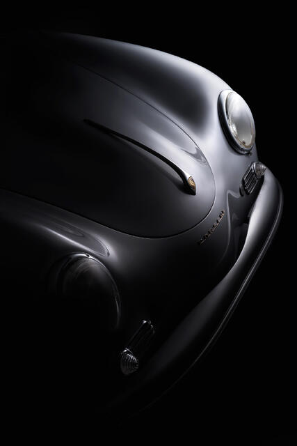 Fine art close-up photograph of the front detail of a silver 1958 Porsche Speedster, emphasizing classic design lines, chrome accents, and vintage craftsmanship