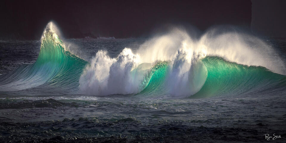 Set of backlit waves breaking along the North Shore of Kauai Hawaii