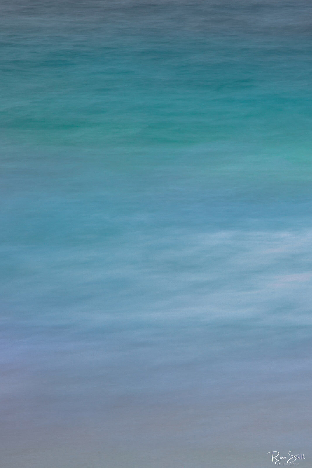 Vertical abstract photography of the Hawaiian waters close up shows the many gorgeous shades of turquoise, blue, white and tan that all come togethers seamlessl