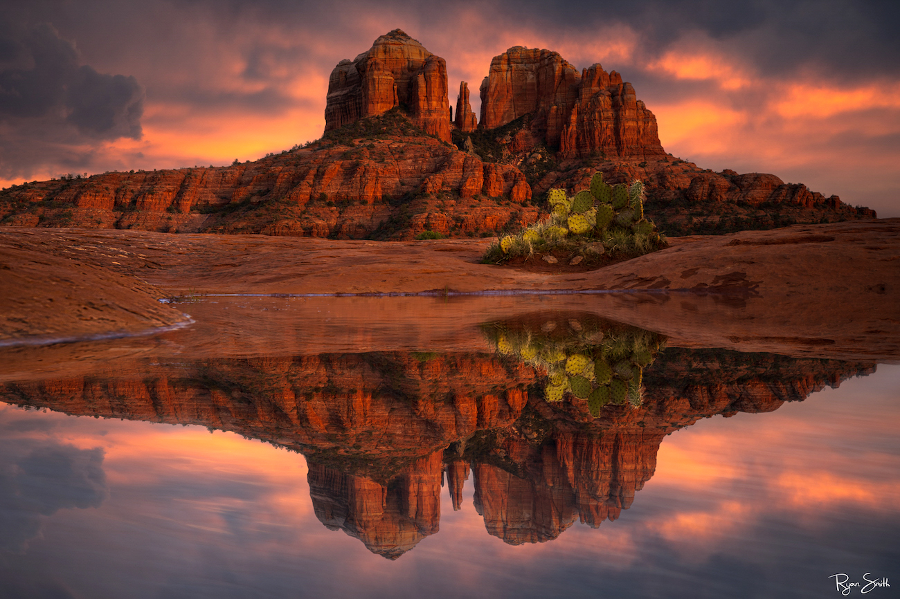 A beautiful sunrise in Sedona Arizona is accentuated by re reflection pond in front of Cathedral Rock
